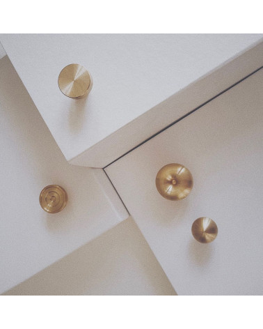 Pomello per mobile in ottone 01 maniglia design messa in risalto su una scala