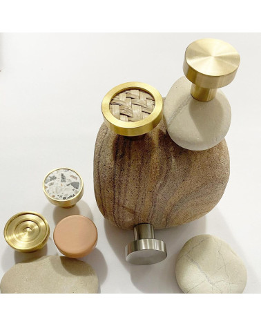 Pomello per mobile in ottone 02 maniglia design disposto su una pietra