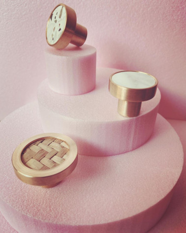 Pomello per mobile in ottone e Terrazzo maniglia design messa in evidenza su un espositore rosa