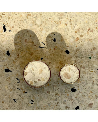 Pomello per mobile in ottone e Terrazzo maniglia design vista dall'alto allineati su una superficie in terrazzo