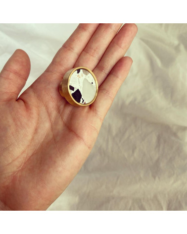 Pomello per mobile in ottone e Terrazzo maniglia design presentato su una mano