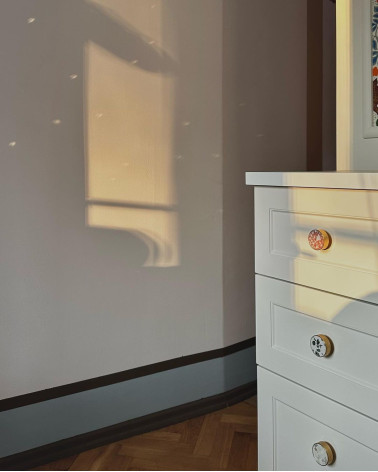 Pomello per mobile in ottone e Pink Terrazzo maniglia design vista inclinata illuminata dai raggi del sole