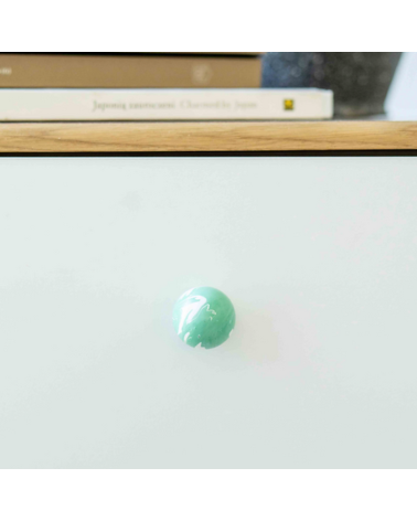 Pomello per mobile in legno di faggio verde intenso maniglia design vista frontale montata su un mobile