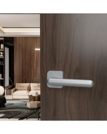 Maniglia per porta NOX in cromo satinato design montata su una porta aperta