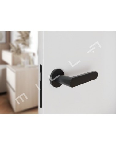 Maniglia per porta nera ALORA design vista dall'alto inclinata montata su una porta