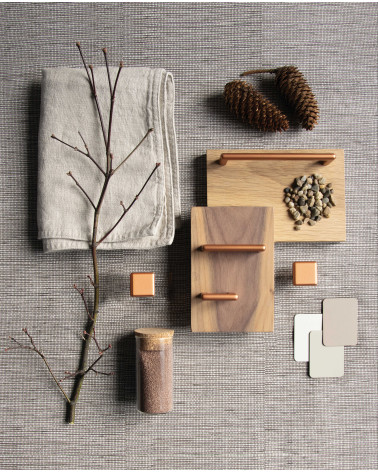 Maniglia per mobile in rame NOX design presentata con materiali decorativi